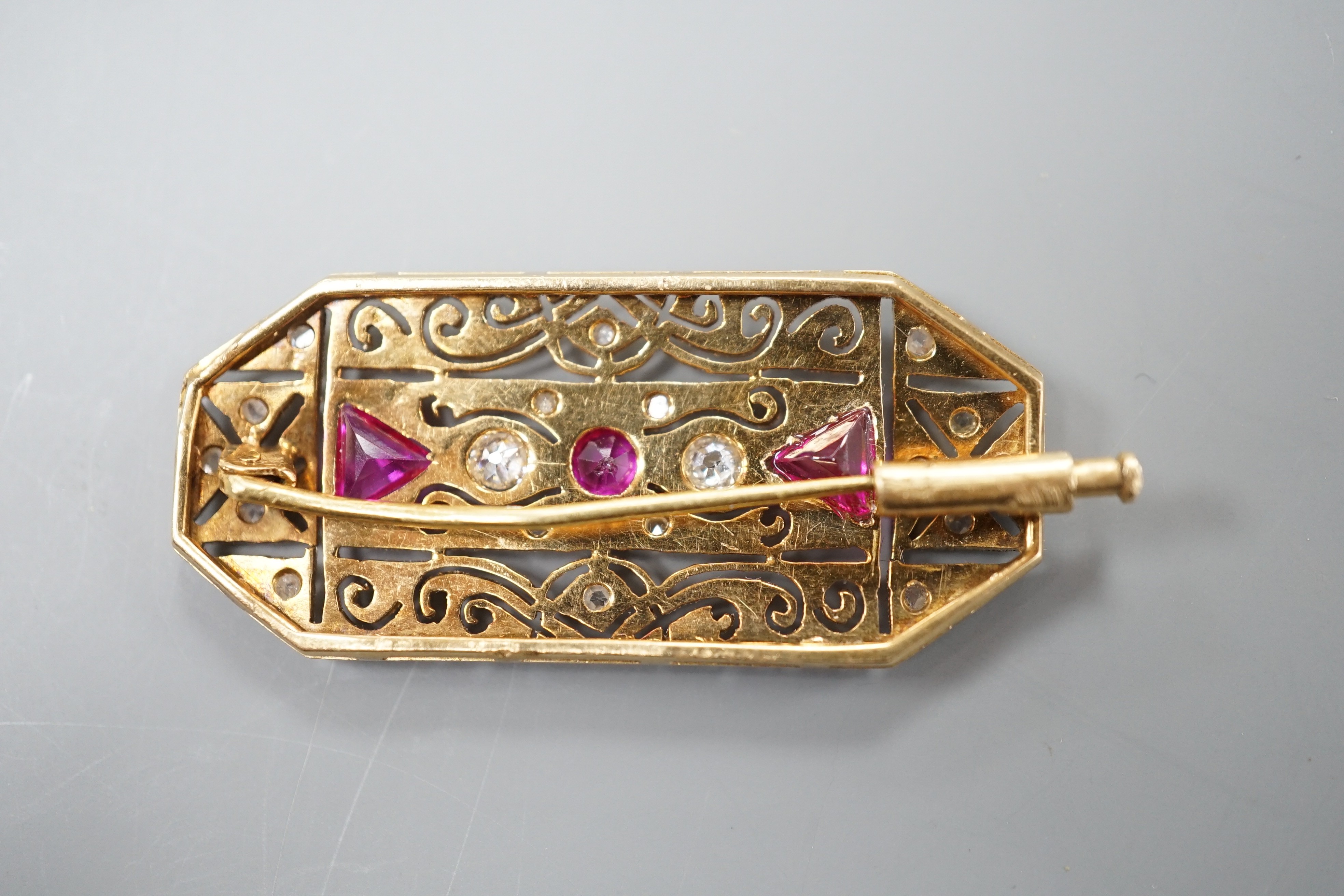 A yellow and white metal, synthetic ruby? and millegrain set diamond octagonal brooch, 40mm, gross weight 7.7 grams.